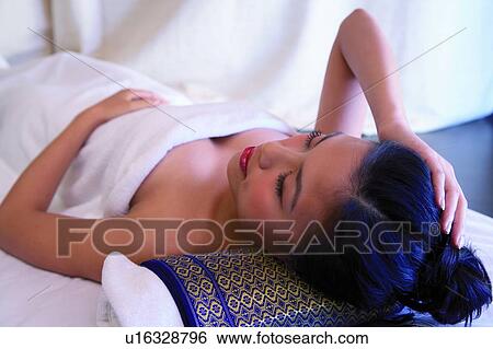 Young woman wrapped in towel, lying down View Large Photo Image Stock Photograph - Young woman wrapped in towel, lying down. Fotosearch