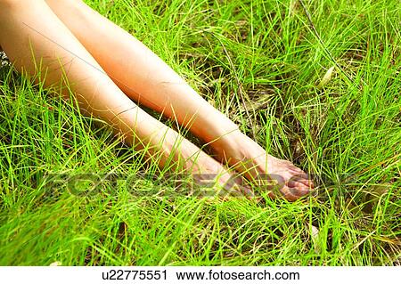 Stock Image - Human legs on grass. Fotosearch