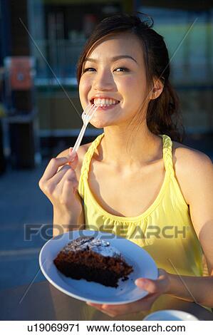 Stock Image - Young Lady Eating Cake. Fotosearch