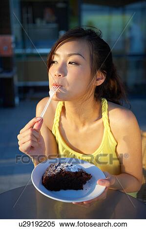 Stock Photography - Young Lady Eating Cake. Fotosearch