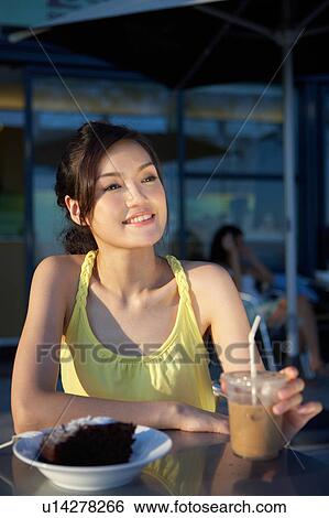 Stock Photograph - Young Lady Sitting at Outdoor Cafe, Looking Away. Fotosearch