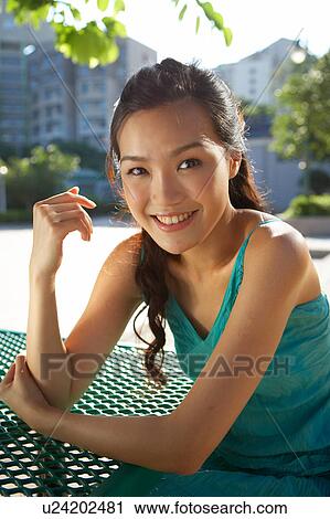 Young Lady Sitting at Table in Park, Smiling View Large Photo Image Stock Image - Young Lady Sitting at Table in Park, Smiling. Fotosearch