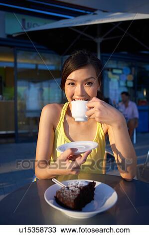 Young Lady Sitting Outdoor Cafe, Holding Cup, Smiling View Large Photo Image Stock Image - Young Lady Sitting Outdoor Cafe, Holding Cup, Smiling. Fotosearch