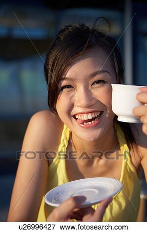 Young Lady Sitting Outdoor Cafe, Holding Cup, Smiling View Large Photo Image Stock Photo - Young Lady Sitting Outdoor Cafe, Holding Cup, Smiling. Fotosearch