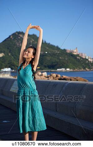Stock Image - Young Lady Stretching, Eyes Closed. Fotosearch