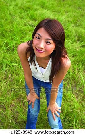 Young woman bowing down, and standing on grass View Large Photo Image Stock Photo - Young woman bowing down, and standing on grass. Fotosearch