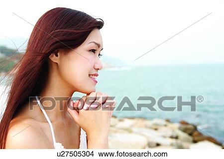 Young woman holding hand, in a praying gesture View Large Photo Image Picture - Young woman holding hand, in a praying gesture. Fotosearch