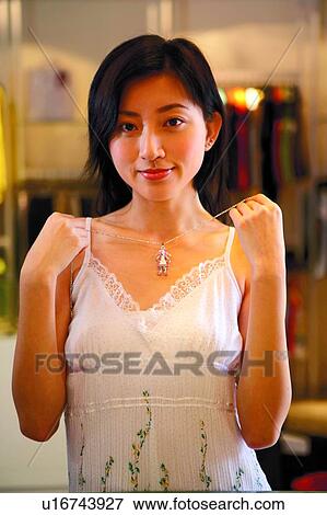 Young woman holding a cutie necklace in front View Large Photo Image Stock Photo - Young woman holding a cutie necklace in front. Fotosearch