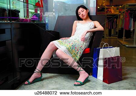 Young woman resting on sofa, in boutique View Large Photo Image Stock Image - Young woman resting on sofa, in boutique. Fotosearch