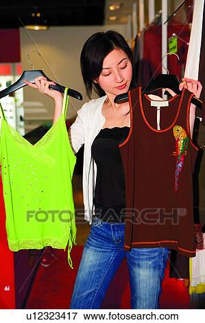 Stock Photo - Young woman shopping at boutique. Fotosearch