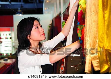 Stock Photo - Young woman shopping at boutique. Fotosearch