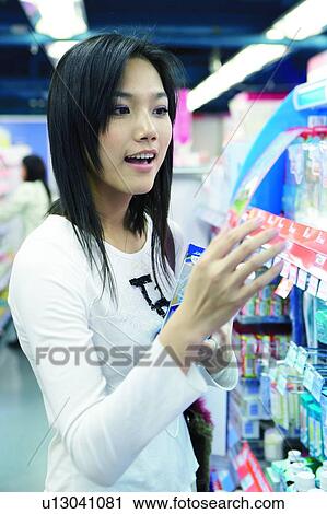 Stock Image - Young woman shopping at store. Fotosearch