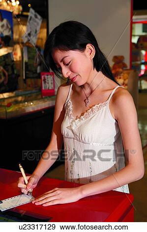 Young woman signing credit card receipts View Large Photo Image Stock Photo - Young woman signing credit card receipts. Fotosearch