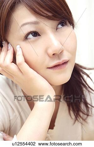 Stock Image - Woman resting her cheek on her hand. Fotosearch