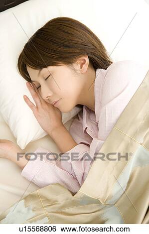 Stock Photograph - Woman sleeping in the bed. Fotosearch