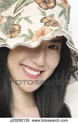 Stock Photography - Woman who puts on a hat. Fotosearch