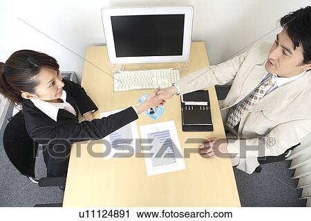 Stock Image - Business people who shakes hands. Fotosearch