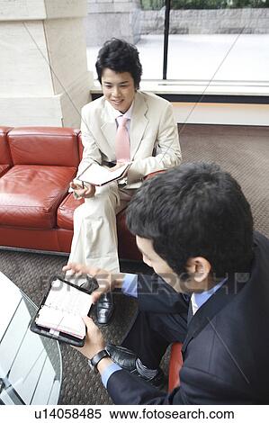 Stock Photography - Businessmen confirming the schedule. Fotosearch