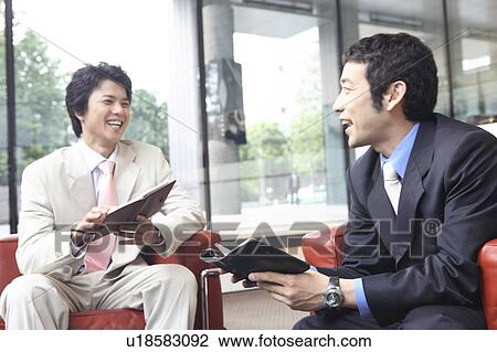 Businessmen having a pleasant chat View Large Photo Image Stock Image - Businessmen having a pleasant chat. Fotosearch