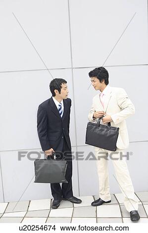Picture - Businessmen having a short meeting. Fotosearch