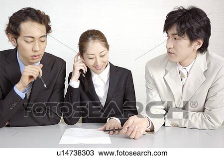 Stock Image - Office workers who do a meeting. Fotosearch
