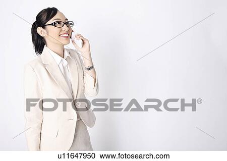 Business lady wearing the glasses who talks with a mobile telephone View Large Photo Image Stock Image - Business lady wearing the glasses who talks with a mobile telephone. Fotosearch
