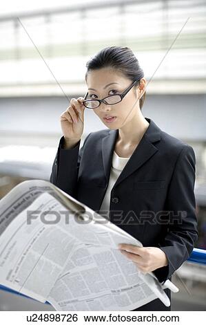 Stock Photograph - Business lady who reads a newspaper. Fotosearch