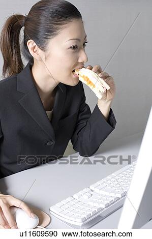 Stock Image - Woman operating a PC. Fotosearch