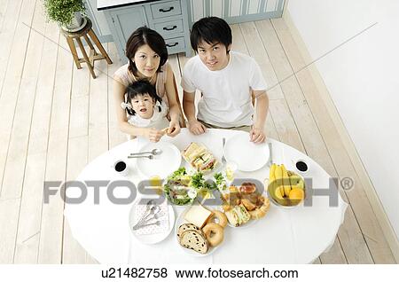 Stock Photo - Family around a dining table. Fotosearch