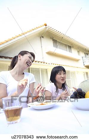 Stock Image - Parent and child eating a meal. Fotosearch
