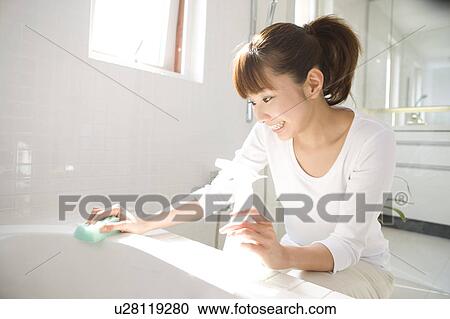 Stock Image - Woman cleaning bathroom. Fotosearch