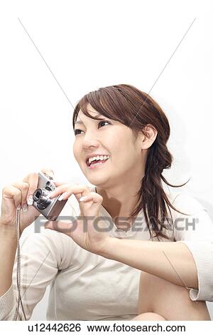 Stock Photograph - Woman having a digital camera. Fotosearch