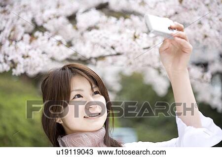 Stock Image - Woman under the cherry tree. Fotosearch