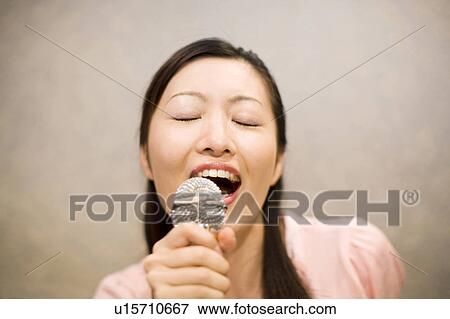 Stock Photo - Woman who does karaoke. Fotosearch