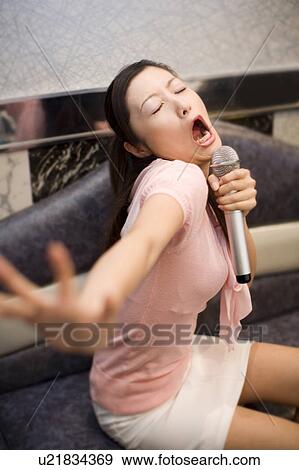 Stock Photo - Woman who does karaoke. Fotosearch
