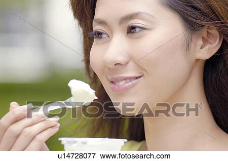 Stock Photo - Woman who eats ice. Fotosearch