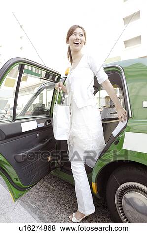 Woman who gets off the taxi View Large Photo Image Stock Photo - Woman who gets off the taxi. Fotosearch