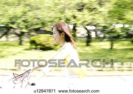 Woman who takes a bicycle View Large Photo Image Stock Image - Woman who takes a bicycle. Fotosearch