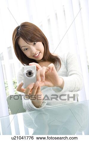 Woman who takes a photograph with a digital camera View Large Photo Image Stock Photograph - Woman who takes a photograph with a digital camera. Fotosearch