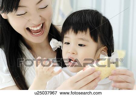 Stock Photo - Infant who eats bread. Fotosearch