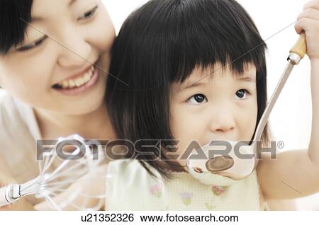 Stock Photograph - Infant who helps cooking. Fotosearch