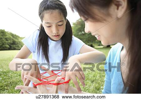 Mother and daughter playing cat's cradle View Large Photo Image Stock Photo - Mother and daughter playing cat's cradle. Fotosearch