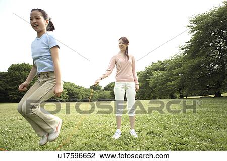 Stock Image - Parent and child doing jumping rope. Fotosearch