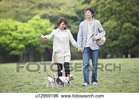 Stock Photograph - Couple taking a walk with the dog. Fotosearch