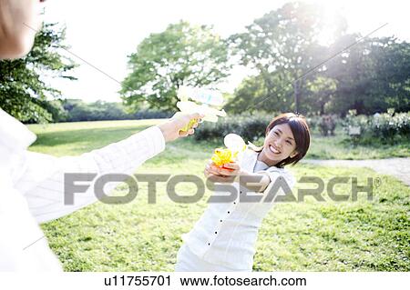 Couple who plays with the water pistol View Large Photo Image Stock Image - Couple who plays with the water pistol. Fotosearch