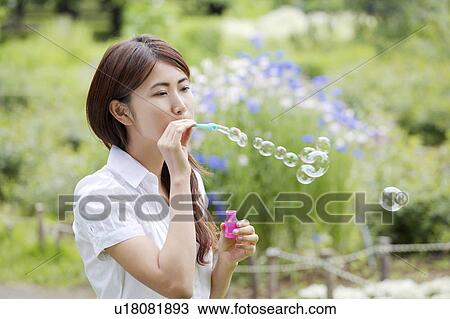 Stock Image - Woman who does a soap bubble. Fotosearch