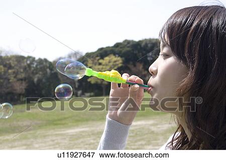 Woman who plays with the soap bubble View Large Photo Image Stock Photo - Woman who plays with the soap bubble. Fotosearch