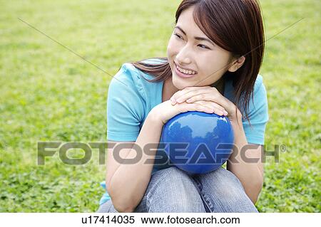 Stock Photography - Woman who sits on the grass. Fotosearch