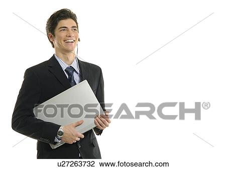 Stock Image - Businessman holding a laptop and smiling. Fotosearch