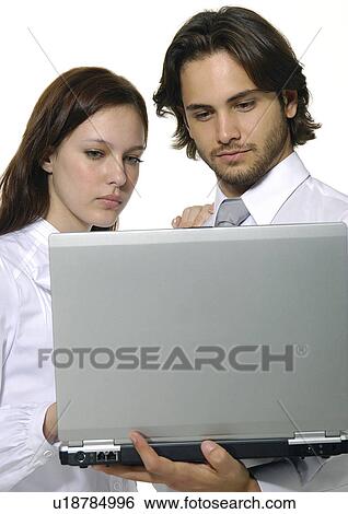 Close-up of a businessman and a businesswoman using a laptop View Large Photo Image Stock Photograph - Close-up of a businessman and a businesswoman using a laptop. Fotosearch